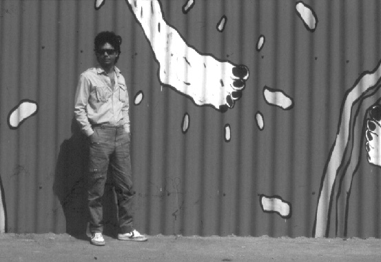 Humberto Castro in front of the mural realized in Berlin, 1985
